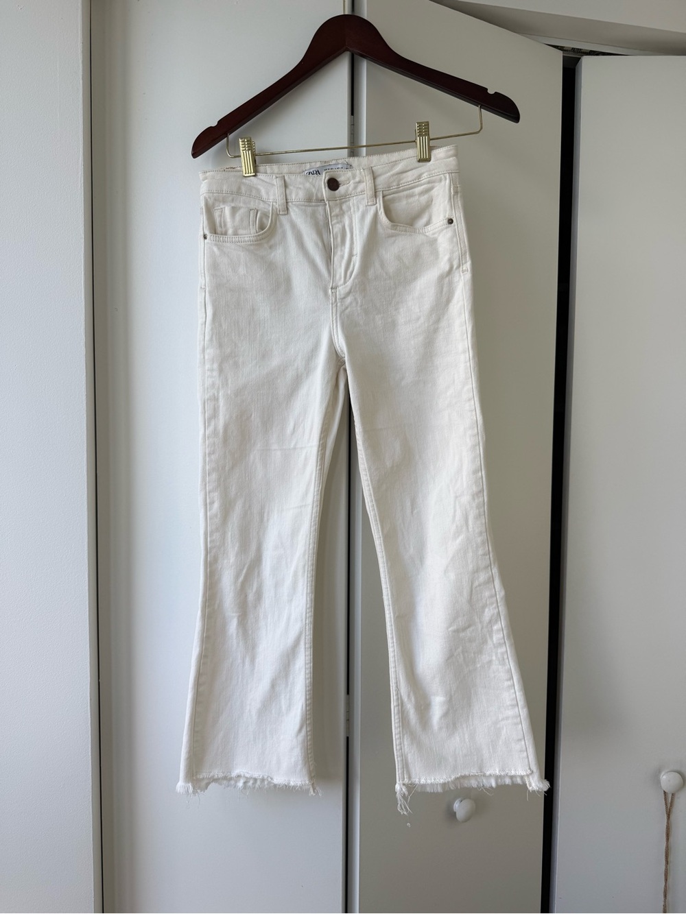 Zara white cropped flare jeans with a raw, frayed edge hemline